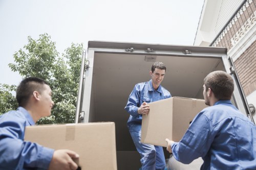Mover carrying furniture from a Limehouse flat